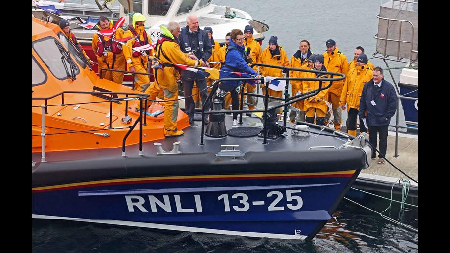 Penny Innes throws Isle of Harris Gin over the bow of Leverburgh Lifeboat to officially name her.