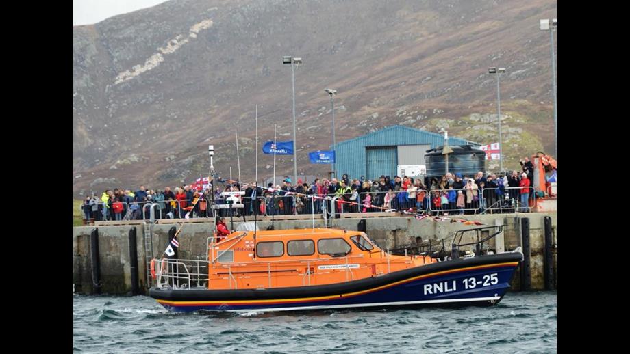 RNLB Stella and Humfrey Berkeley 13-25 beside large crowd of people on Leverburgh pier