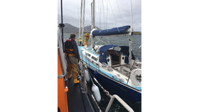 Leverburgh RNLI prepare to take the 12m yacht under tow. Both boats side by side at sea.