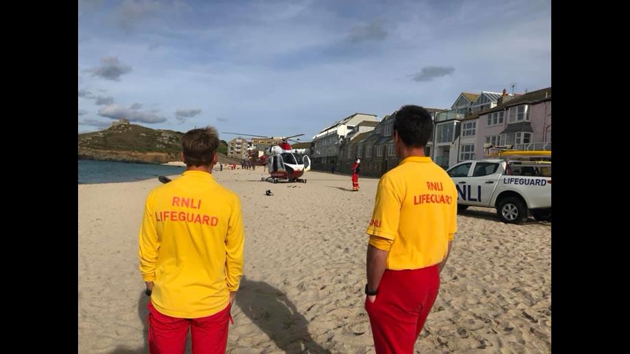 RNLI lifeguards at Porthmeor with the Cornwall Air Ambulance on the beach
