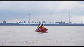 RNLI lifeboat on the water with the inflatable dinghy protruding vertically at the rear
