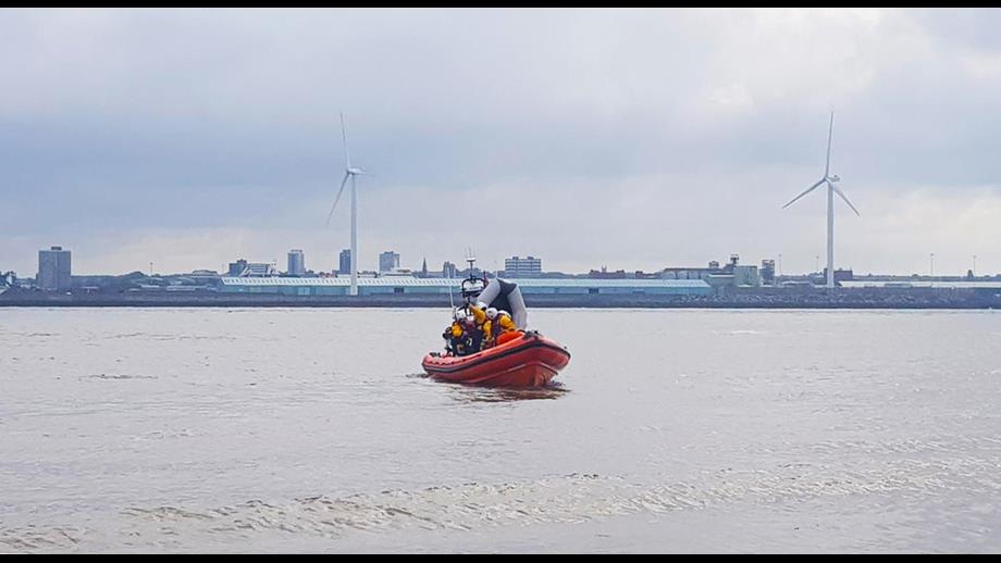 RNLI lifeboat on the water with the inflatable dinghy protruding vertically at the rear