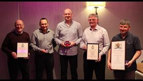 A picture of five of the Macduff Crew standing in a line with their Long Service Medals and certificates