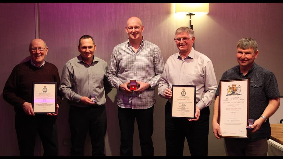 A picture of five of the Macduff Crew standing in a line with their Long Service Medals and certificates