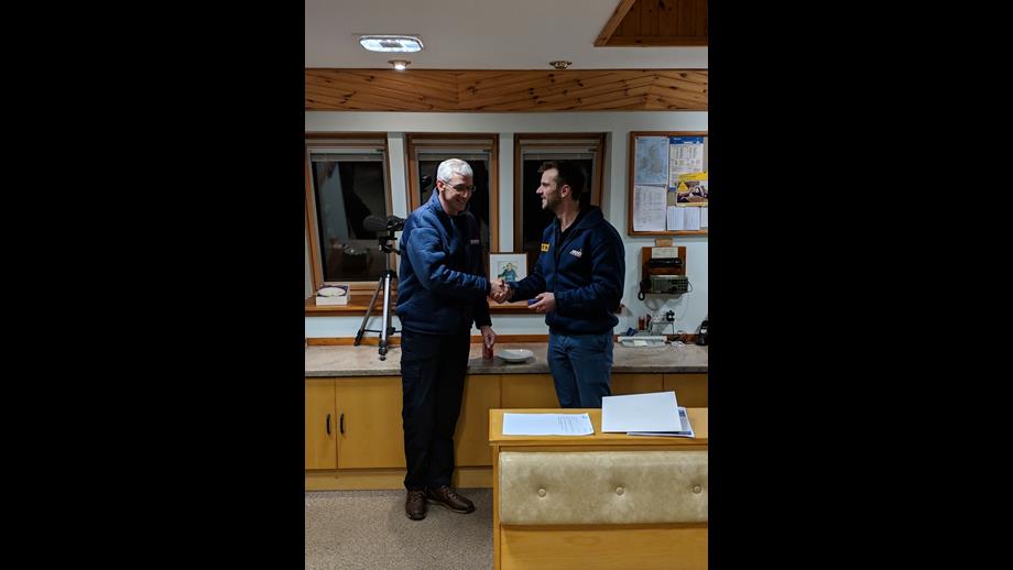 David Park standing shaking hands with Henry Weaver who has a Long Service Medal in his hand