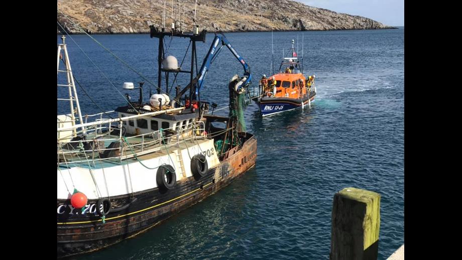 Leverburgh RNLI Lifeboat to the stern of the casualty vessel with line attached.
