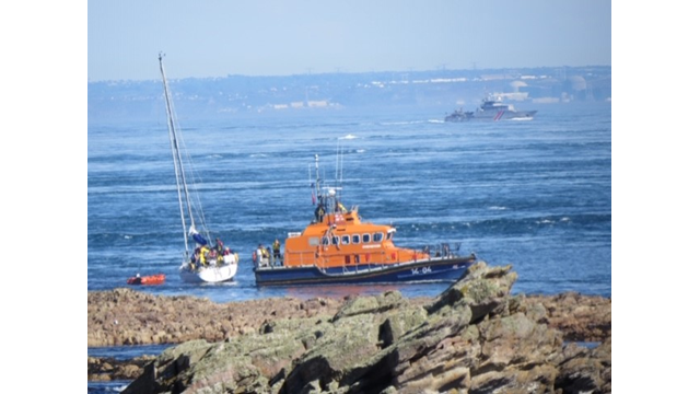 Roy Barker I, casualty and RNLI inflatable boat, with military patrol boat in background.