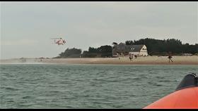Wide photo showing the sea, lifeboat in the foreground and helicopter about to land by Hayling lifeboat station.