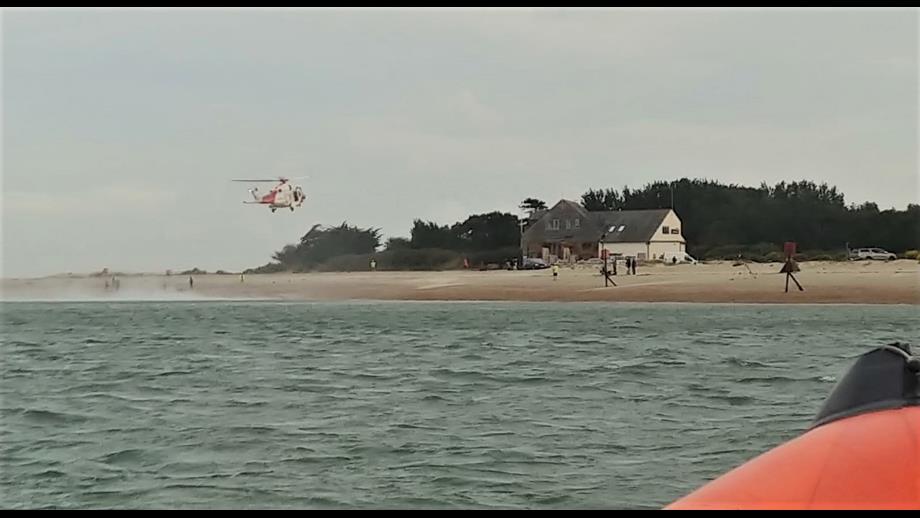 Wide photo showing the sea, lifeboat in the foreground and helicopter about to land by Hayling lifeboat station.