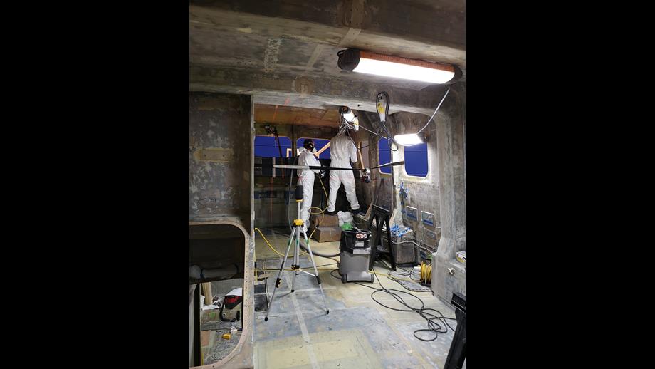Two workers inside the stripped out wheelhouse of a Severn class lifeboat 