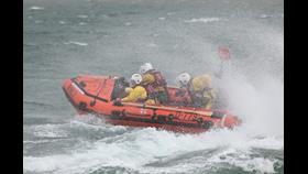 The D-Class lifeboat is turning sharply in spray