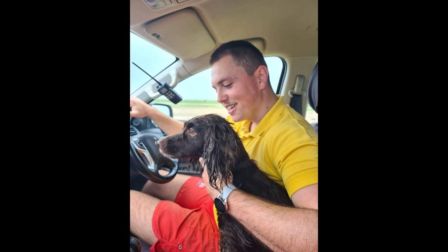 Dog Coco with RNLI lifeguard Owain, waiting to be reunited with owner
