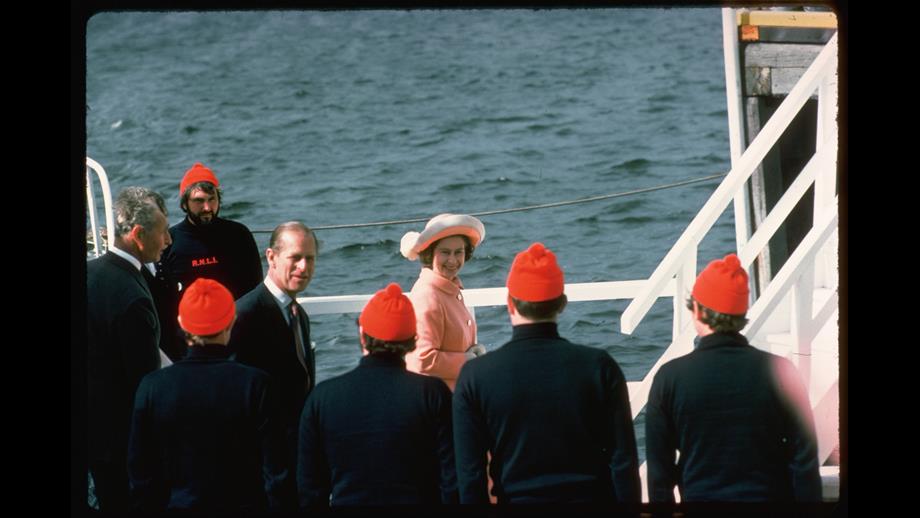 Her Majesty Queen Elizabeth II meeting members of Hartlepool's volunteer crew wearing red woollen bobble hats at the naming ceremony of Waveney-class lifeboat The Scout on 14 July, 1977