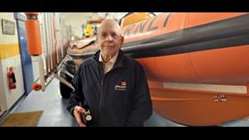 Chris McFadyen with his Long Service Award recognising 40 years' service, standing in front of the St Catherine's inshore lifeboat, Eric W Wilson (B class, Atlantic 85)