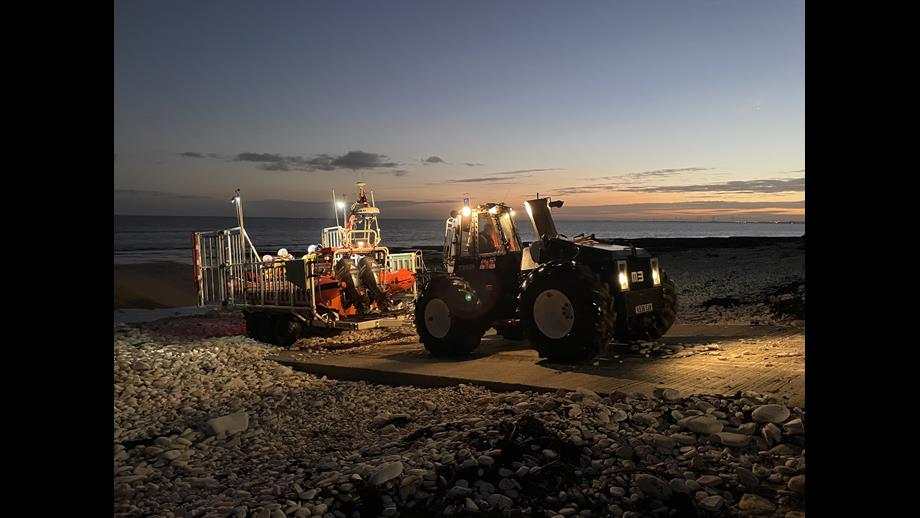 Tractor with lifeboat on the carriage, driving up the slipway from the beach at South Landing.