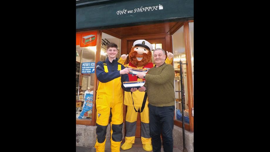 Steve Tokelove (right), of the Wee Shoppie in Gardenstown’s Main Street, is seen here exchanging a well-filled RNLI collecting box for an empty one, ready to take its place by the till