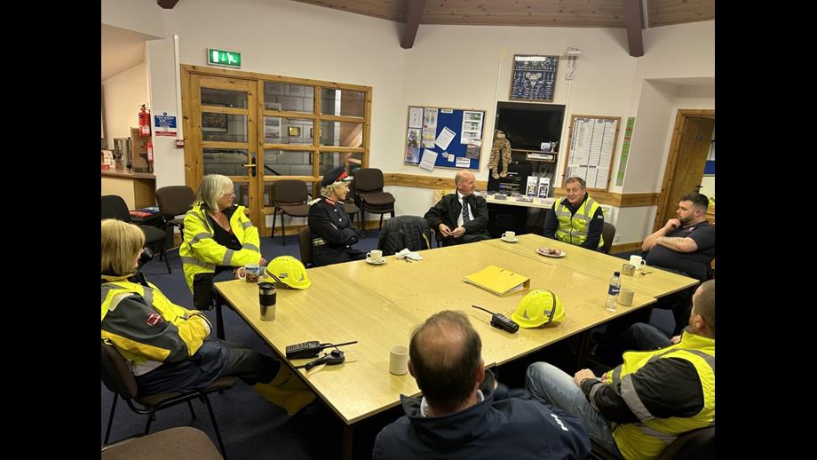 The Lord Lieutenant and lifeboat crew in the station sat around a table with tea and biscuits
