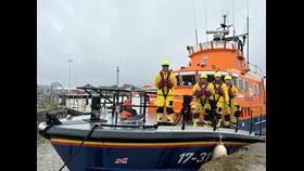 Station Mechanic Liam Dunnett standing on the bow of the lifeboat with crew stood behind him