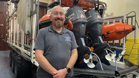 Rob Mitchell standing in the boathouse with lifeboat behind