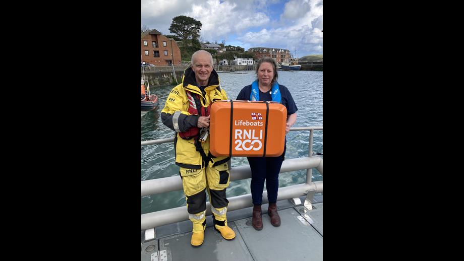 Padstow RNLI head launcher and retired lifeboat crew volunteer Robert Norfolk and Fundraising Guild Treasurer Kathryn Nicholas with the scroll