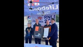 Four people holding the RNLI Scroll