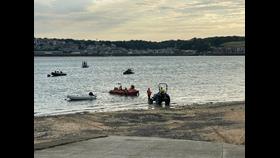 As the sun sets behind Padstow, Rock volunteer lifeboat crew launch into the Camel Estuary.