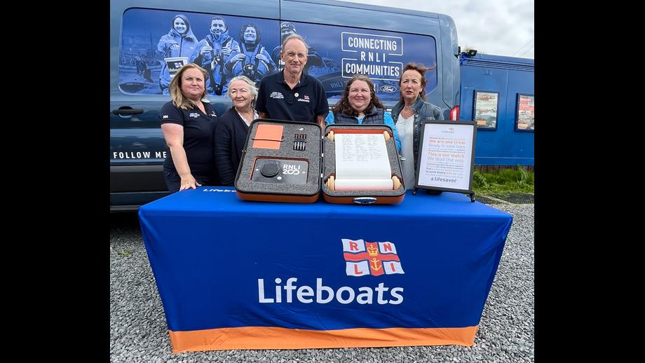 Peter Kennedy, a Station Mechanic at Lough Derg RNLI stands with his family either side of him after signing the RNLI scroll