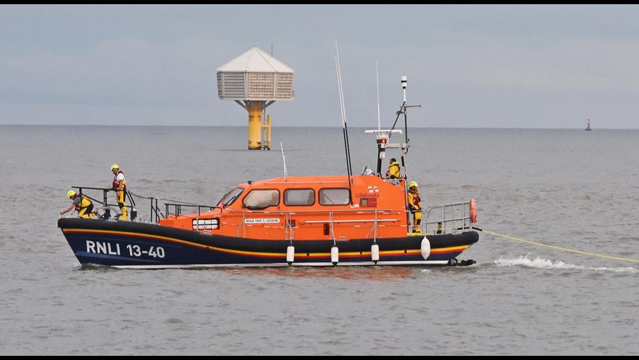 Lowestoft RNLI relief lifeboat Erics Legend towing past the kittiwake hotel off Lowestoft South Beach