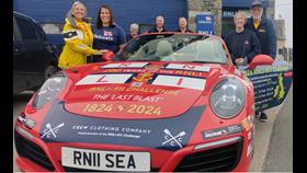 Belinda and James Richardson with members of Kilmore Quay RNLI crew standing around 'Splash' the Porsche