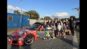 Volunteers from Lough Derg RNLI stand by the Porsche 911 car with the station behind them