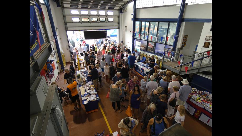 Stalls for games etc line two sides of a large room with people clustered round them