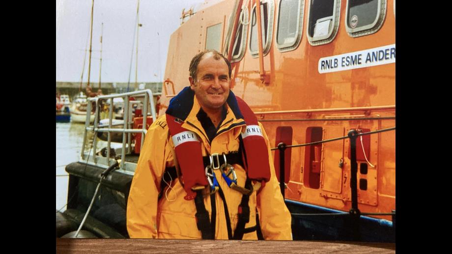 a lifeboatman stood besides a lifeboat