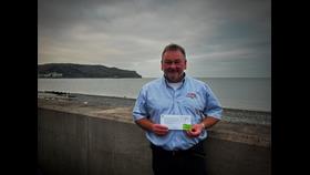 Andrew holding his letter of thanks and badge. 