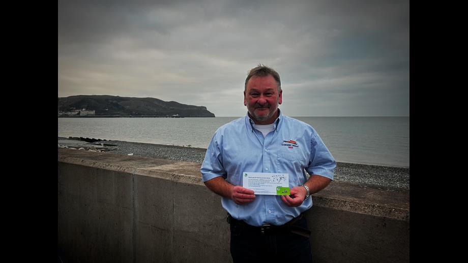Andrew holding his letter of thanks and badge. 