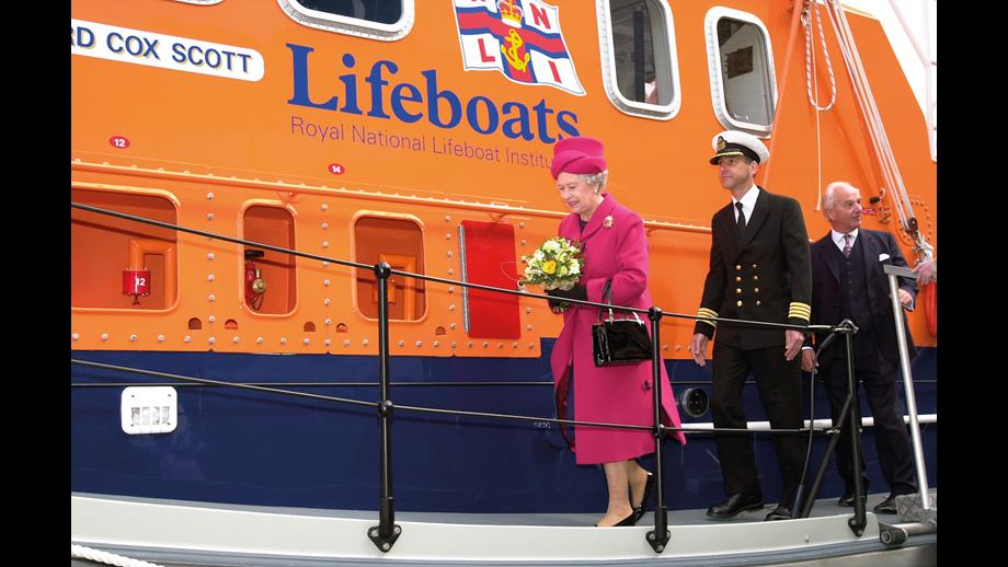 Her Majesty Queen Elizabeth II going aboard Richard Cox Scott accompanied by Falmouth’s Harbour Master Captain Mark Sansom and RNLI Chairman Peter Nicholson, was taken during the naming ceremony on 1 May 2002