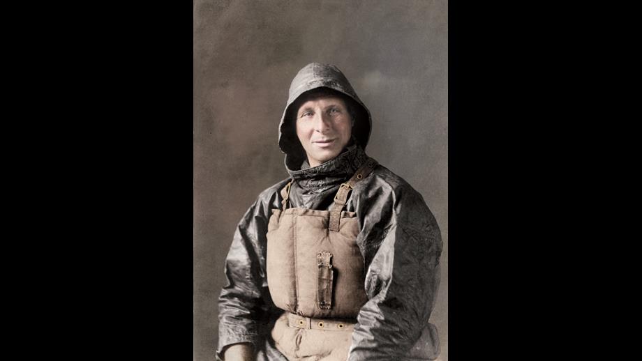 Portrait image of man in black oilskins and old lifejacket.