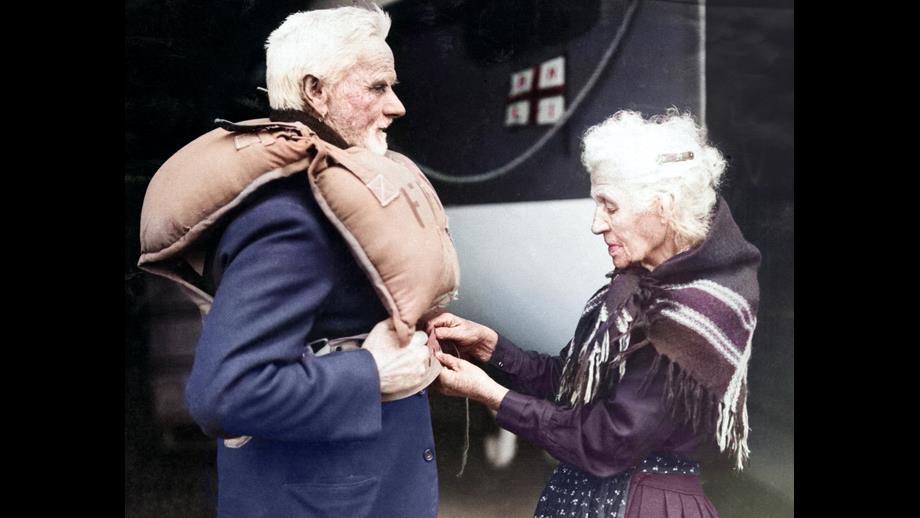 Coxswain William Brown on left adjusting buoyancy aid with wife on the right.