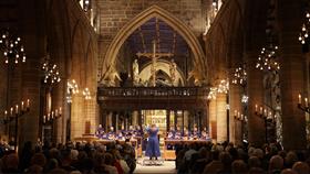 Community gathered with choir in an ambient lit Cathedral.