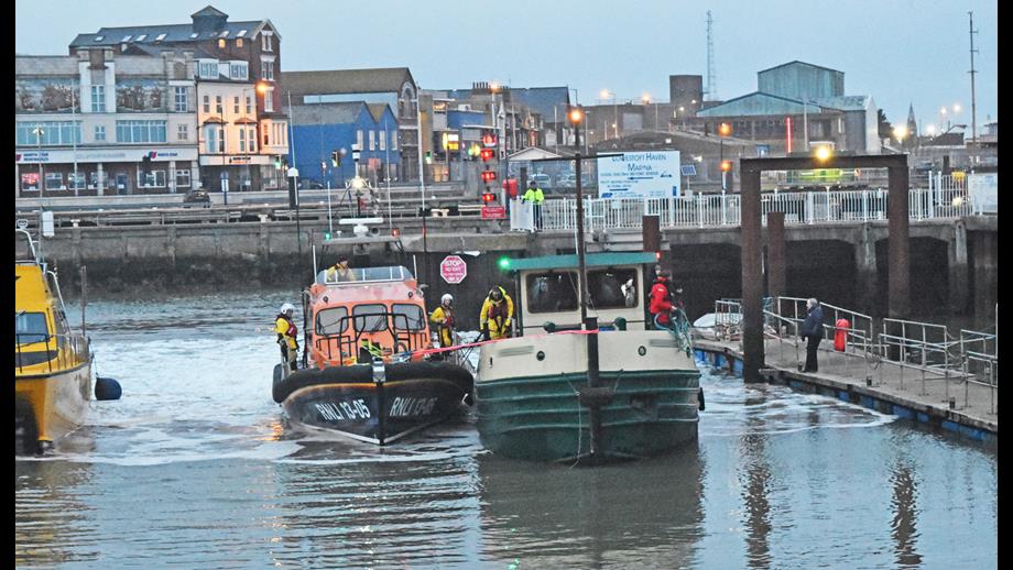 Lowestoft RNLI lifeboat prepares to moor the former tug in Lowestoft Harbour