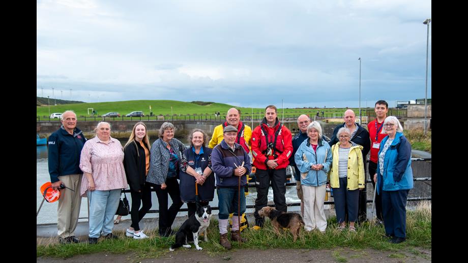 Group of people standing on harbourside 