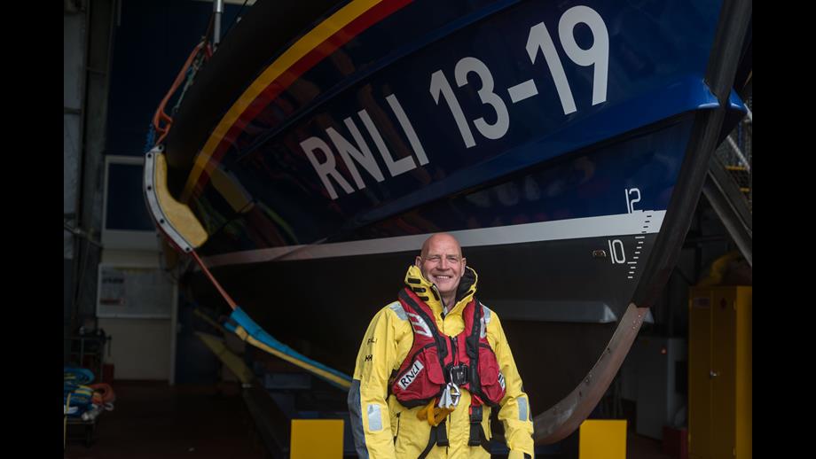 John Stobbart in RNLI gear standing in front of lifeboat 