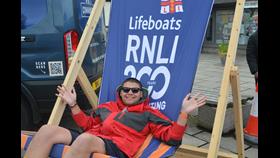 Man relaxing in giant RNLI deckchair