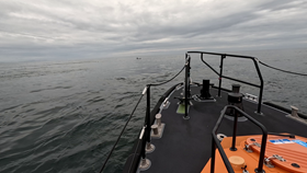 Bow of lifeboat approaching dinghies in distance