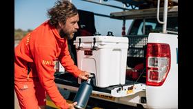 RNLI lifeguard filling their water bottle using a Yeti cooler