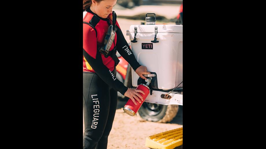 RNLI lifeguard filling their water bottle using a Yeti coole