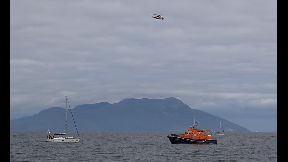 Casualty vessel, lifeboat and Coastguard helicopter on scene with Rum in background