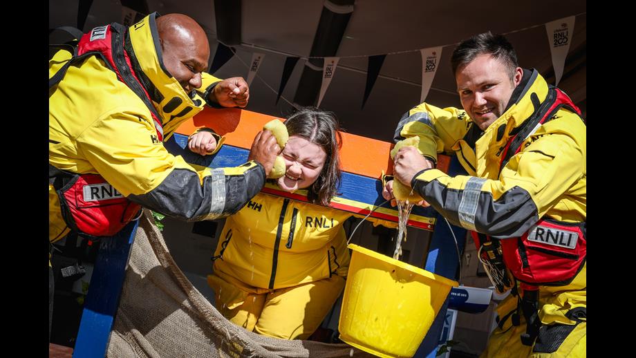 Crew members Ali Hussein and Niall Fagan soak Emily Clarkson in the Flag weekend Stocks.