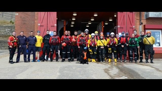 Agencies involved in promoting water safety gather outside Cullercoats lifeboat station wearing their organisation's PPE