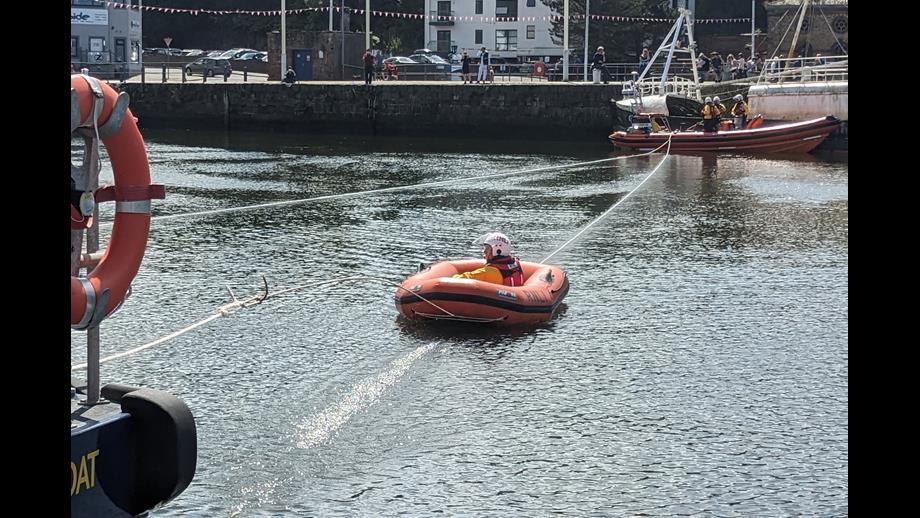 Volunteres from St Bees RNLI being pulled over the water from a fishing boat to Workington RNLI Shannon demonstrating a manoeuvre called Breaches Buoy