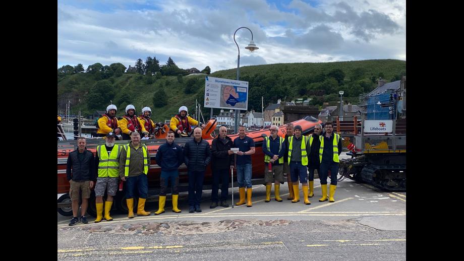 Stonehaven RNLI volunteer crew photographed in front of Atlantic 85 with Jim Smith presenting his donation